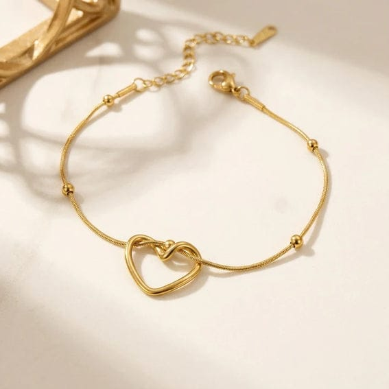 Stainless Steel Heart Bracelet features a delicate golden chain with a minimalist intertwined heart pendant.